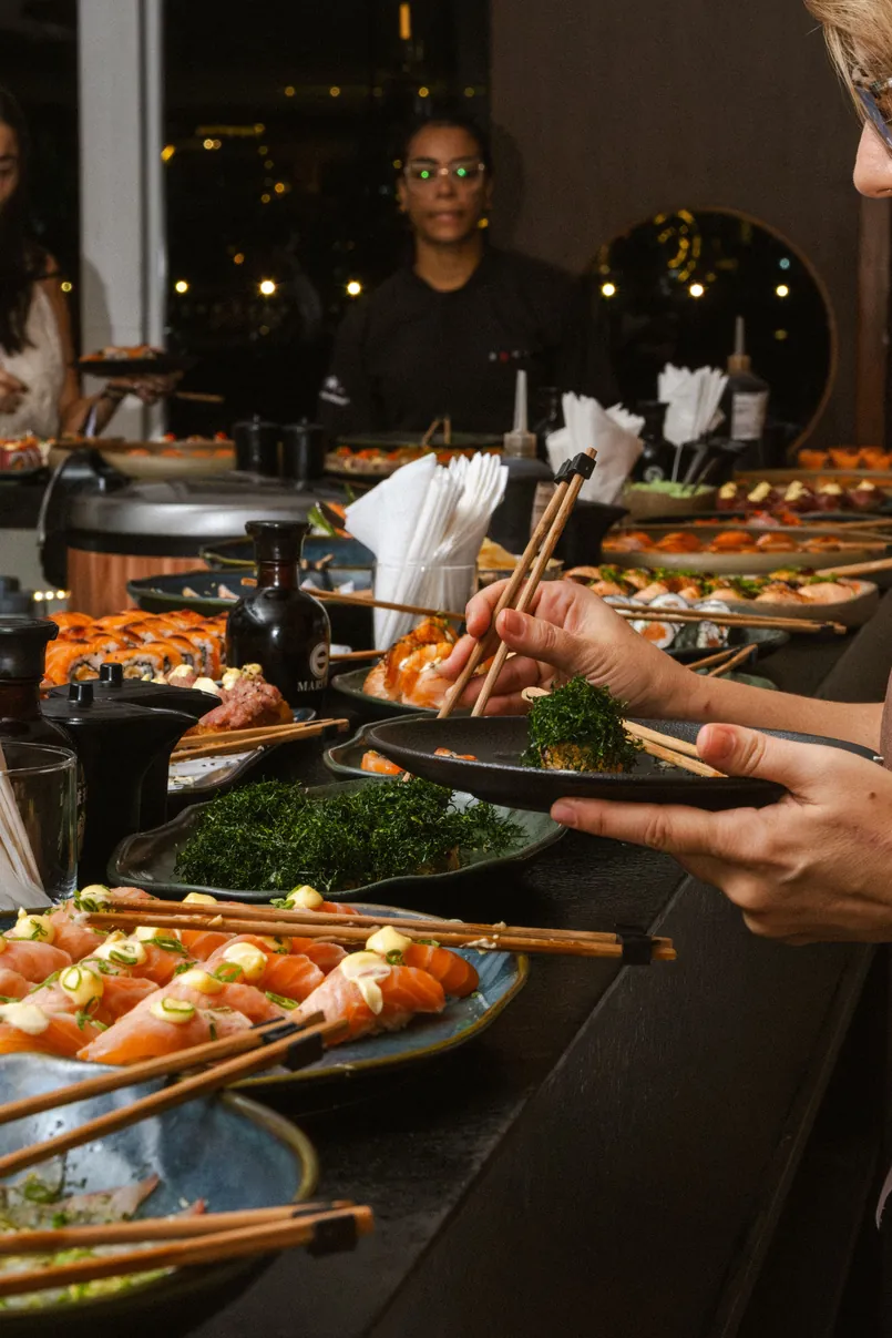 Atendente servindo peças de sushi aos convidados